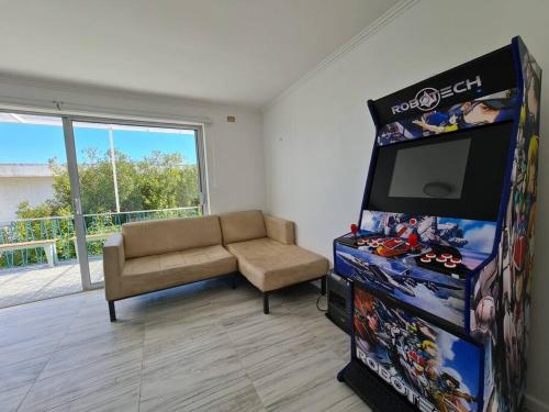 a living room with a couch and a video game at Espectacular Casa Tres Pisos, cap. 21 Personas. in Algarrobo