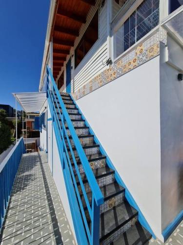 a staircase leading up to a building with a blue railing at Espectacular Casa Tres Pisos, cap. 21 Personas. in Algarrobo