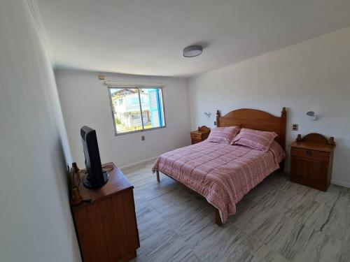 a bedroom with a bed and a tv in it at Espectacular Casa Tres Pisos, cap. 21 Personas. in Algarrobo