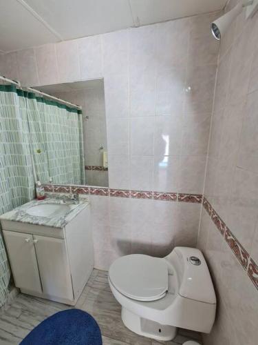 a bathroom with a white toilet and a sink at Espectacular Casa Tres Pisos, cap. 21 Personas. in Algarrobo