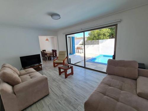 a living room with a couch and a television and a pool at Espectacular Casa Tres Pisos, cap. 21 Personas. in Algarrobo