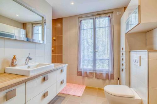 La salle de bains est pourvue d'un lavabo, de toilettes et d'une fenêtre. dans l'établissement Villa Saint-Mard - King Size bed - 10min Aéroport CDG 25min Paris by train, à Saint-Mard