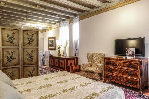 ヴェローナにあるラ コルテ ディ ジュリエッタのベッドルーム(ベッド1台、テレビ、椅子付)