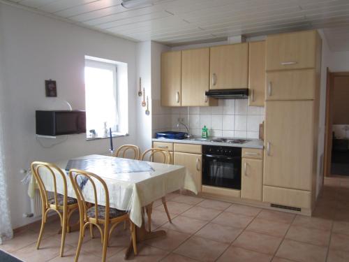 a kitchen with a table and chairs and a table and a kitchen with a stove at Hotel Waldparkstube in Bad Schonborn