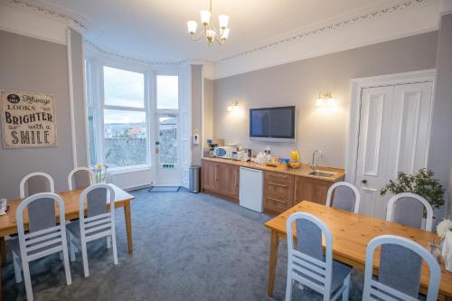 een keuken en eetkamer met een tafel en stoelen bij Granite City Guest House in Aberdeen