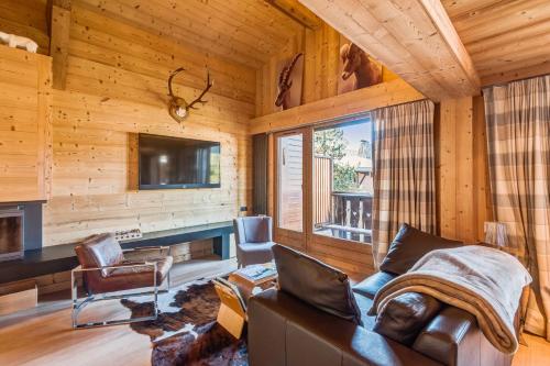 a living room with a couch and a tv at Wonderful appartement in a chalet with balcony - Megève - Welkeys in Megève
