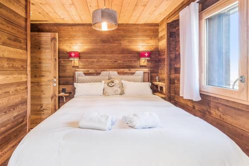 une chambre avec un grand lit avec des serviettes dessus dans l'établissement Le Hameau des Cimes - Welkeys, à Megève