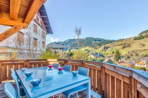a blue table and chairs on a wooden deck at Le Hameau des Cimes - Welkeys in Megève