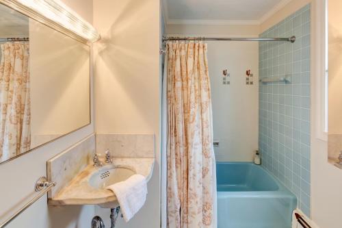 y baño con lavabo y bañera azul. en Streamside Victorian, en Margaretville