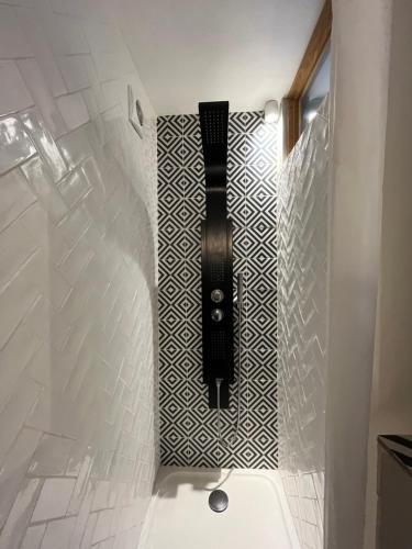 a bathroom with a black and white tile wall at Le clos sainte Marie in Roquefort-les-Pins