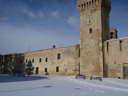 a large brick building with benches in front of it at Torre della Botonta in Castel Ritaldi
