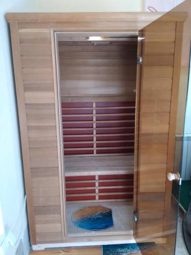 a closet with a wooden cabinet with its door open at Hostel Bata in Kanjiža