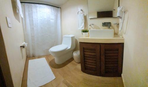 een badkamer met een wit toilet en een wastafel bij Casa Luz Downtown Apartments in Tulum in Tulum