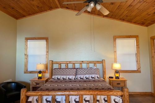 a bedroom with a wooden bed with two windows at Cleveland Cabin with Pool, Hot Tub and Mountain Views! in Cleveland