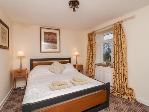 a bedroom with a bed with two towels on it at 7 Scarah Bank Cottages in Ripley