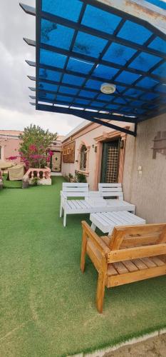 a patio with picnic tables and a blue umbrella at Al Moltaqua Chalet in Taif