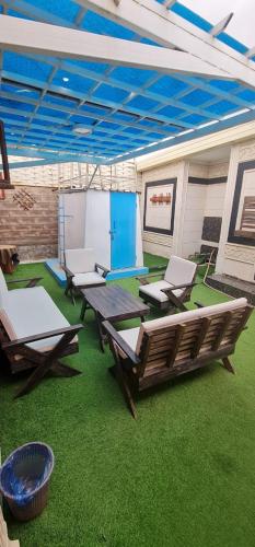 a patio with picnic tables and chairs on grass at Al Moltaqua Chalet in Taif