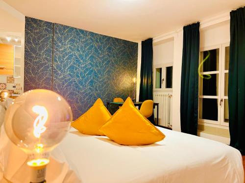 a bedroom with a bed with yellow pillows and a lighted lamp at Crops City Stay Apartment 14 in Trieste