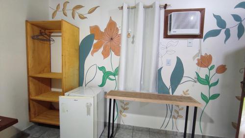 a room with a wall with flowers on it at Recanto dos Pássaros - Sana Chalés in Sana