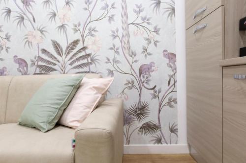 a living room with a couch and a floral wall at Contrasto Apartments in Viterbo