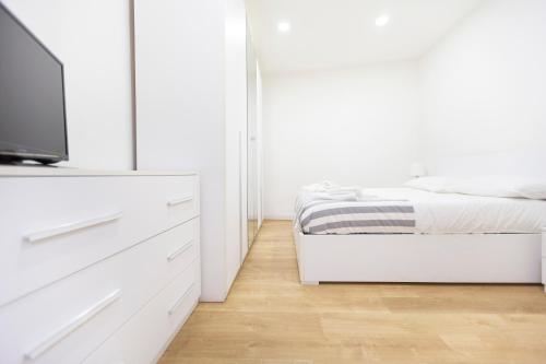 a bedroom with a bed and a dresser with a tv at Contrasto Apartments in Viterbo