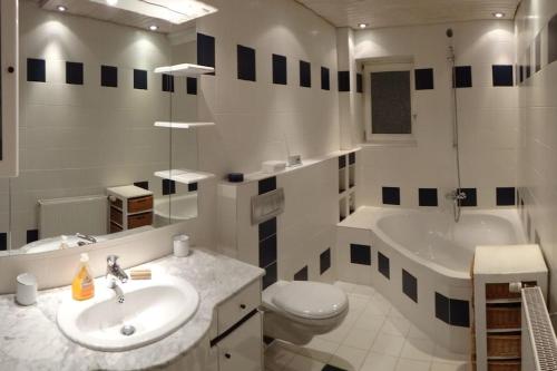 a bathroom with a sink and a toilet and a tub at 2 BR beautyful vacation home / Ferienhaus Brunsberg in Buchholz in der Nordheide