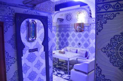 Zimmer mit blauen und weißen Wänden und einem Tisch in der Unterkunft LA casa Dar Rayan in Fès