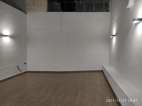 an empty room with white walls and a wooden floor at Bonita y amplia casa con patio, en centro ciudad in Merida