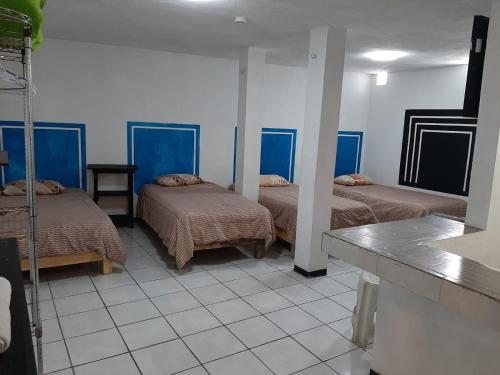 um quarto com três camas e uma mesa em Hotelito Ejido em Sanctórum