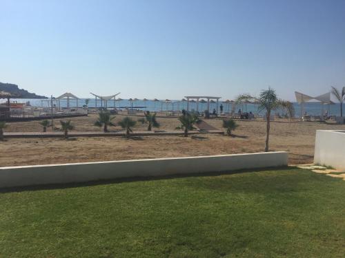 a view of a beach with palm trees and buildings at The Best Apartment on the beach 'Caesar Beach' Bogaz, North Cyprus in Boğaz