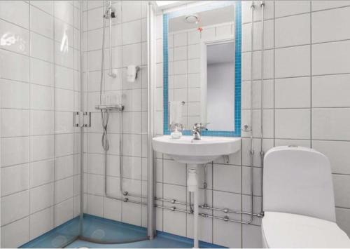 a bathroom with a sink and a toilet and a mirror at Gjøvik Overnatting in Gjøvik
