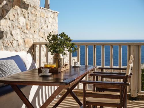 a wooden table on a balcony with a view of the ocean at Orfos Villas in Agios Nikolaos