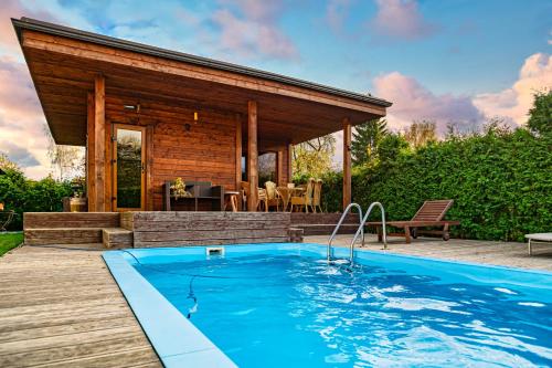a house with a swimming pool in front of a house at Amber Villa in Rīga
