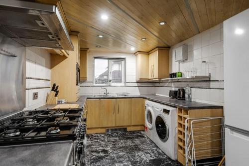 a kitchen with a stove and a washing machine at Cressingham House Manchester in Manchester