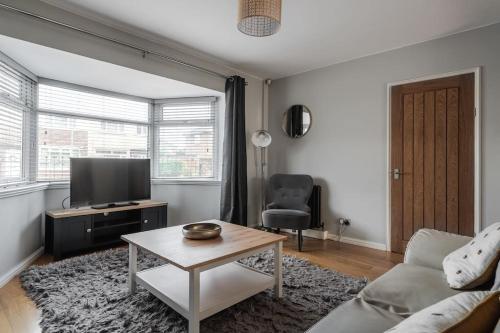 a living room with a couch and a tv and a table at Cressingham House Manchester in Manchester