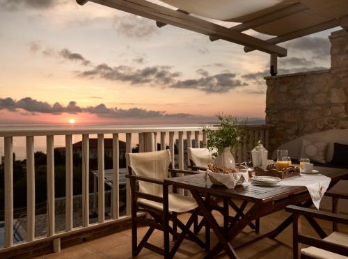 a table on a balcony with a view of the ocean at Orfos Villas in Agios Nikolaos