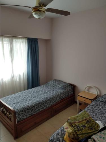 1 dormitorio con 2 camas y ventilador de techo en Alojamiento Marisa en Carhué