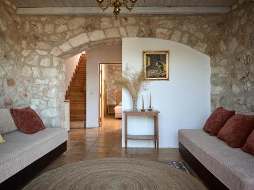 a living room with two couches and a stone wall at Orfos Villas in Agios Nikolaos