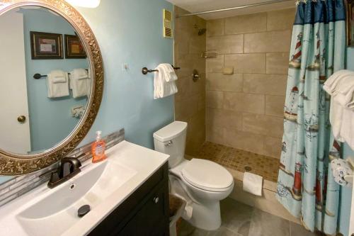 a bathroom with a toilet and a sink and a mirror at Beachside St Augustine Vacation Rental Condo! in Coquina Gables