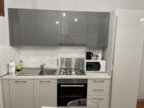 a kitchen with a sink and a microwave at APPARTAMENTO IL RESTAURO in Cuneo