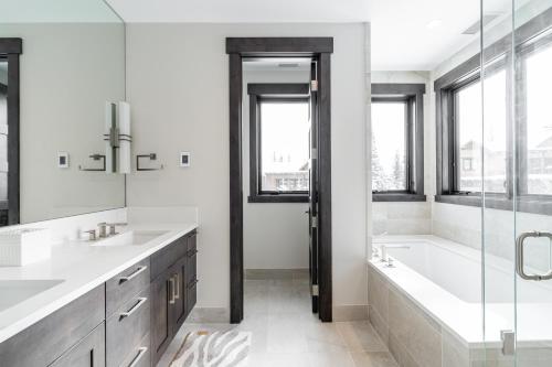 a bathroom with a tub and two sinks and a bath tub at Spanish Peaks Highlands Cabin 18 in Big Sky