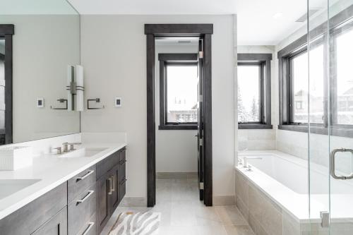 a bathroom with a tub and two sinks and a bath tub at Spanish Peaks - Highlands Cabin 18 in Big Sky