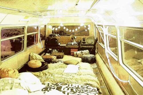 una habitación con sofás y camas en una furgoneta en Le YESLOWBUS en fête en Carla-Bayle