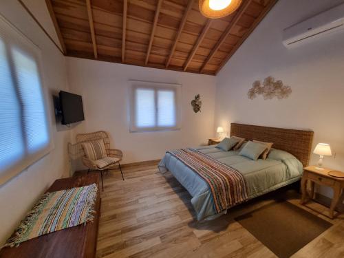 sypialnia z łóżkiem, telewizorem i krzesłem w obiekcie villa los vaqueros w mieście Garafía