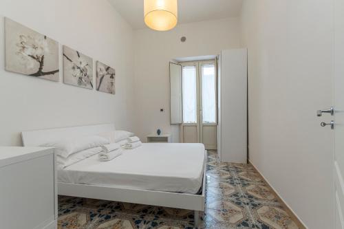 a white bedroom with a bed and a window at ELEGANT APARTMENT IN TAORMINA in Taormina