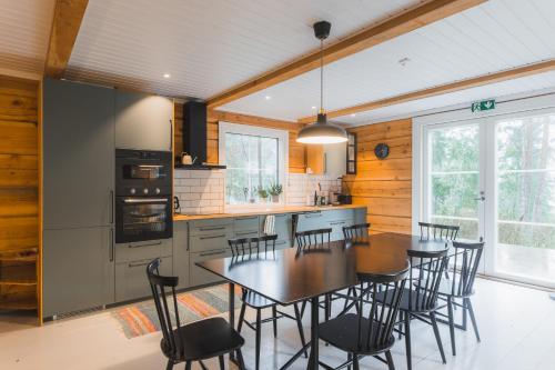 a kitchen with a table and chairs in a room at Brännskär Cottages & Glamping in Pargas