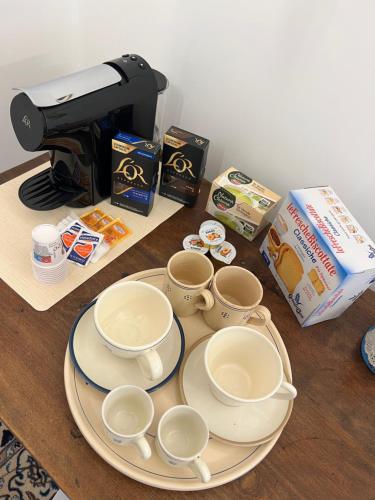 a table with plates and cups and a coffee maker at Suite Battisti 7 in Lecce