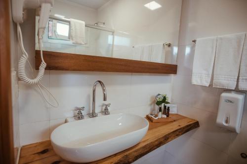 a white sink sitting under a white towel rack at Grande Hotel Canela in Canela