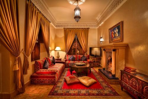 sala de estar con sofá y chimenea en Riad Kniza en Marrakech