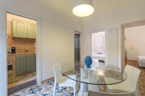 a dining room with a glass table and white chairs at ELEGANT APARTMENT IN TAORMINA in Taormina